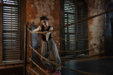 Boxer woman taking break on ropes, intense cinematic training session pause