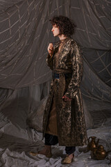 Stylish male model in fusion suit blending modern tailoring with Arabian fairytale elements.
