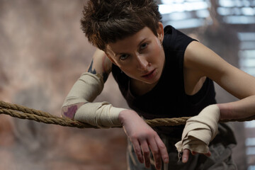 A woman in a boxing gym, portrait by the ropes, close-up. cinematic style, Respite before training, motivation
