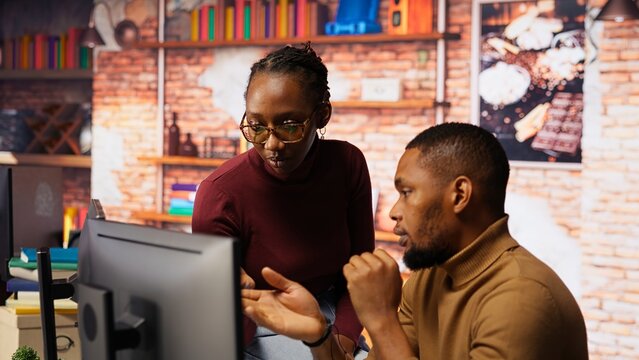 Teamworking programmers creating deep learning models analyzing data in artificial intelligence development agency. African american IT coworkers programming in AI startup office, camera B
