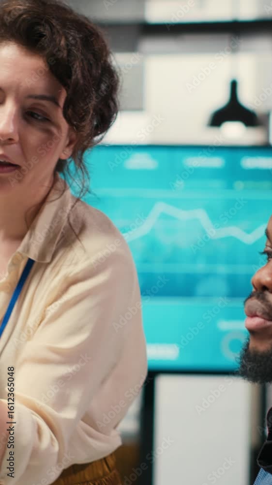 Poster vertical video colleagues engaging in discussion and consulting around performance metrics, leveragi