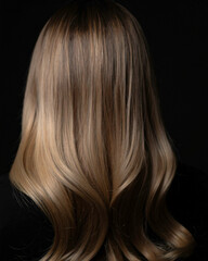 Naklejka premium Curly blonde hair on a black background. 