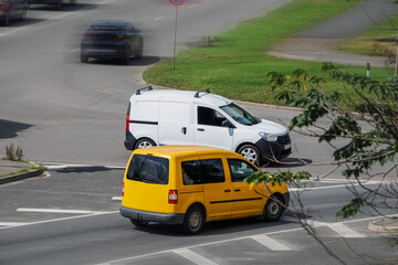 Small commercial vehicle on the street. Yellow and white compact cargo vans