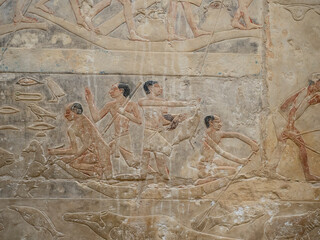 Relieve egipcio antiguo con figuras humanas y ofrendas esculpidas en piedra