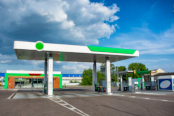 Blurred image of a modern gas station. Urban background with residential buildings. Concepts of...