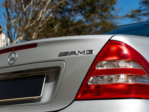 AMG badge and taillight on a Mercedes-Benz C32, Close-up detail of a classic silver sedan

