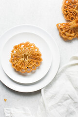 Overhead view of sassafa northern nigerian snack, top view of rosette cookies on a white plate	