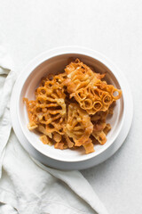 Overhead view of sassafa northern nigerian snack, top view of rosette cookies on a white countertop