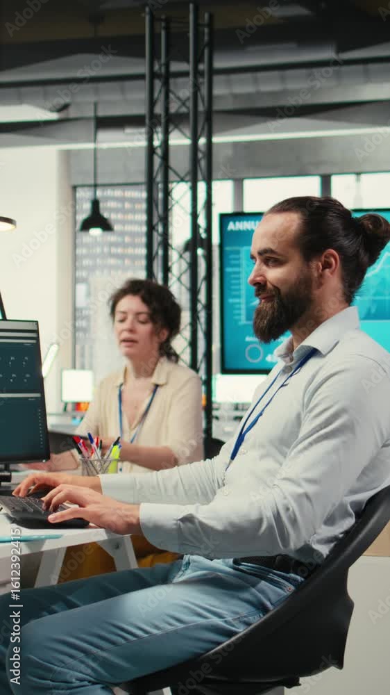 Poster vertical video office employee reviewing kpi metrics on monitor and analytics on files, building a v