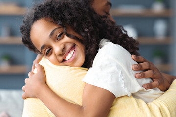 Closeup portrait of happy african american father and daughter embracing while having fun together...