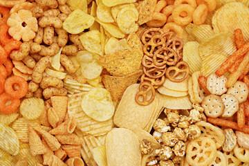 Colorful mix of salty snacks for beer varieties: chips and pretzels, onion rings and crackers....