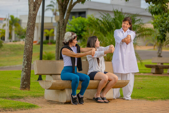 Caregiver Assisting Senior Woman with Arm Exercises – Outdoor Wellness - Powered by Adobe