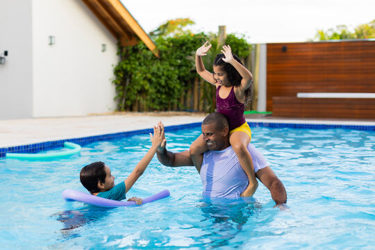 Father Playing with Children in Swimming Pool – Fun and Bonding