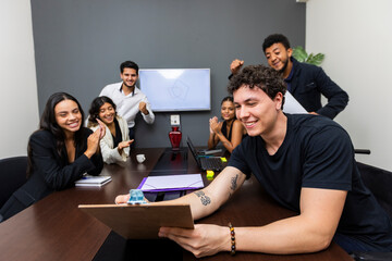 Young team collaborating and smiling during office meeting