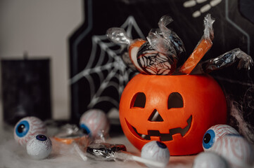 spooky halloween banner with pumpkin full of candles, candies and other decorations. trick or treat concept 