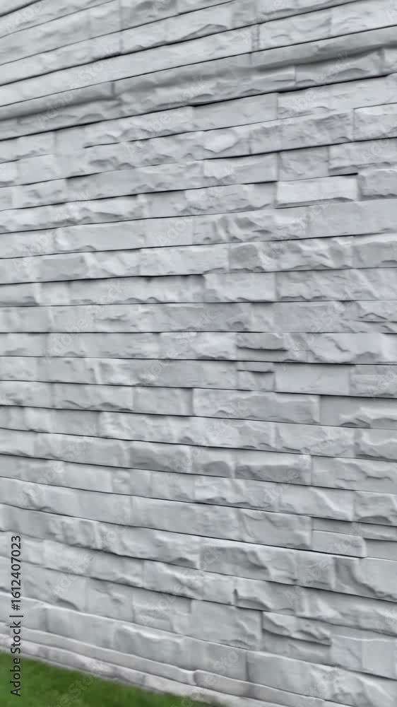 Poster Close-up view of staggered white stone cladding with a rough texture creating an interior wall, providing a modern natural design element.