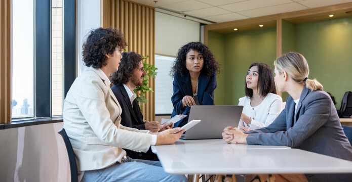 African woman sale manager is showing annual report chart to her colleagues in the executive meeting for next year plan with market share increase for global business and investment usage