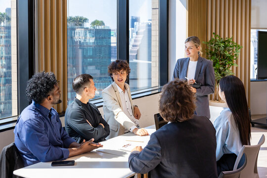 Caucasian woman sale manager is showing annual report chart to her colleagues in executive meeting for next year plan with market share increase for global business and investment concept