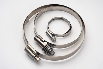 Three stainless steel hose clamps of different sizes, used for securing pipes and hoses in mechanical, plumbing, or automotive systems. Plumbing, Engineering, Automotive, Industry