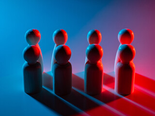 Wooden figures grouped in pairs under blue and red lighting, symbolizing teamwork, relationships,...