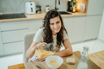 Young caucasian woman eating cereals for breakfast at home	