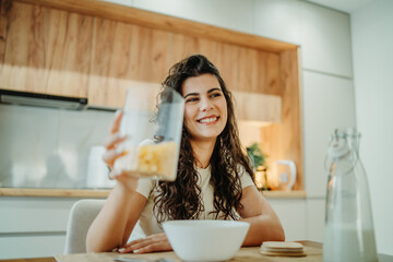 Young caucasian woman eating cereals for breakfast at home	