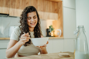 Young caucasian woman eating cereals for breakfast at home	