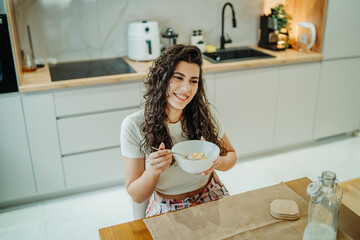 Young caucasian woman eating cereals for breakfast at home	