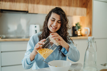Young caucasian woman eating cereals for breakfast at home	