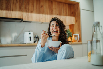 Young caucasian woman eating cereals for breakfast at home	