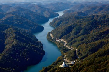 Serene River Carving Through Lush Green Mountains