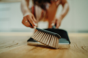 Close up of young caucasian woman's hand cleaning the flor with brush	