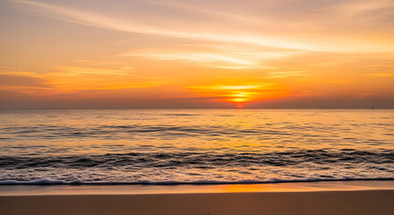 Obraz premium The sun sets over the tranquil ocean, casting a golden glow on the beach