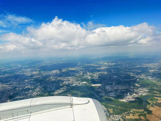Blue sky with clouds over beautiful landscape, view through airplane window