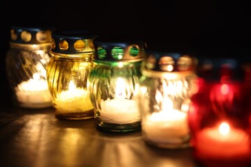 Many grave candles on black background, closeup
