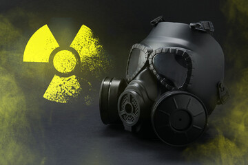 Radiation threat. Gas mask, radioactive sign and smoke on grey table