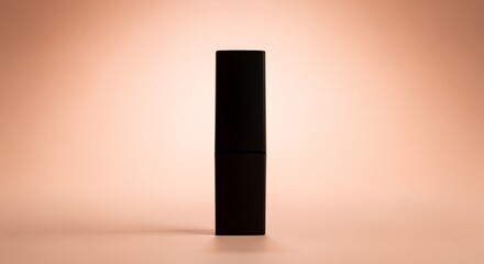 A sleek black cosmetic tube stands elegantly against a soft, -colored backdrop, creating a minimalist product display ideal for beauty or skincare advertising.