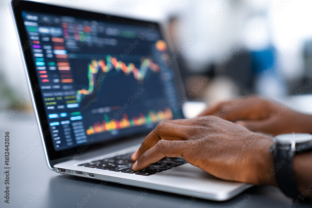 Poster hands typing on laptop displaying financial graphs and charts during market analysis in a modern wor