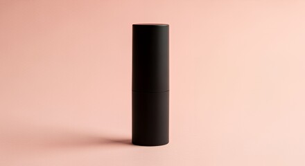 A sleek black cylindrical container stands upright against a soft background, showcasing its simple yet elegant design.
