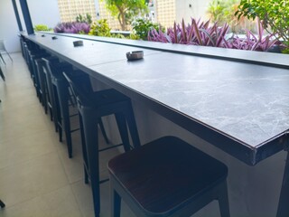 Outdoor Bar Seating with Black Stools and Marble-Effect Countertop