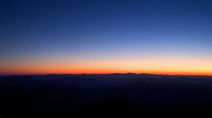 Obraz premium Mountain landscape bathed in twilight hues of deep blue and fading sunset colors. 