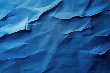 Fototapeta premium Close-up of layered and torn blue paper creating textured ridges and shadows with varying shades of blue