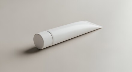 A pristine white tube of cream or lotion rests on a minimalist gray , showcasing its simple and elegant design.