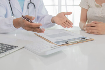 In an Asian hospital, male and female health care workers in uniforms and lab coats consult patients with stethoscopes, provide treatment, and smile confidently.