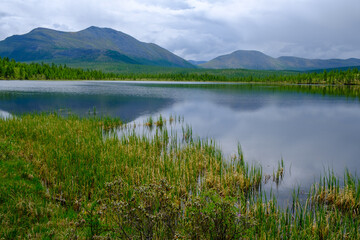 Sunset panorama of small lake with mountain reflection in Siberia, Buryatia, Russia
