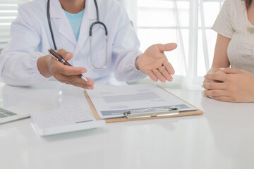 In an Asian hospital, male and female health care workers in uniforms and lab coats consult patients with stethoscopes, provide treatment, and smile confidently.