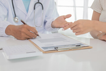 In an Asian hospital, male and female health care workers in uniforms and lab coats consult patients with stethoscopes, provide treatment, and smile confidently.