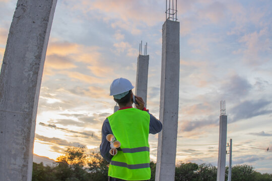 Confident young male engineer wearing hard hat, checking checklist and blueprints at construction site, leading project planning with expertise, safety and professionalism. - Powered by Adobe