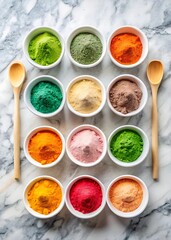 Overhead view of colorful powders in bowls with wooden spoons