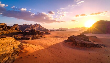Naklejka premium Dramatic sunset casts a warm glow over the expansive desert landscape, showcasing rugged rock